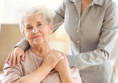 Alte Dame legt Ihre hand um eine andere Person